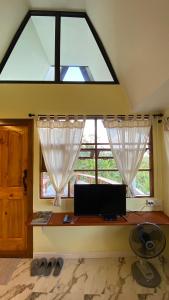 a desk with a computer in a room with a window at ภูคำฮ้อมคลิฟฟ์ลอดจ์ แอนด์ โฮมสเตย์ Phu come home cliff Lodge & Homestay in Ban Phu Hi