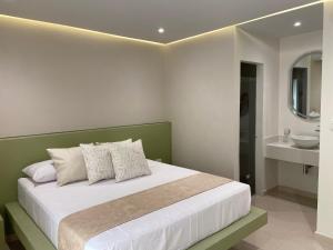 a bedroom with a bed with a sink and a mirror at Techos Azules in Taganga