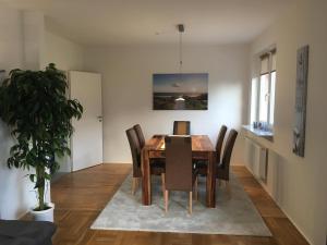 a dining room with a wooden table and chairs at Ferienwohnung Kajüte in Wees