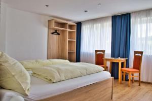 a bedroom with a bed and a table and chairs at Hotel Gasthof Altmann in Warzenried