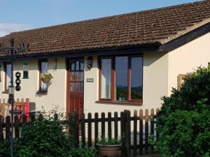 a house with a fence in front of it at The Rock self-catering holiday cottage and garden lodges in Coleford