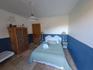 Dormitorio azul con cama y sofá en Ferme de Roccapina en Sarragia