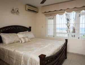 um quarto com uma cama grande e uma janela em Ocho Rios 2 Bedroom Apartment/Flat em Ocho Rios