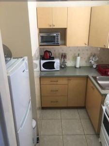 uma pequena cozinha com um frigorífico branco e um micro-ondas em Ocho Rios 2 Bedroom Apartment/Flat em Ocho Rios