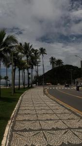a cobblestone street with palm trees on the side of a road at Apartamento Tá Querendo Praia! in Guarujá