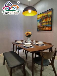 einen Esstisch mit Stühlen und ein Gemälde an der Wand in der Unterkunft D'Pristine Design Apartment by TGP in Nusajaya