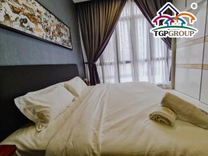 ein Bett mit einem Handtuch in einem Schlafzimmer in der Unterkunft D'Pristine Design Apartment by TGP in Nusajaya