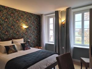 um quarto com uma cama com uma parede floral em Chambres d'hôtes Domaine des Formes em Effiat