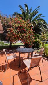 una mesa y dos sillas y una mesa y flores en Chalet Mar del Plata en Mar del Plata