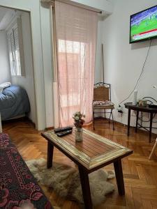 sala de estar con mesa de centro y TV en Lugar encantador en Recoleta en Buenos Aires