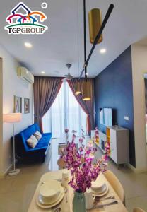 ein Wohnzimmer mit einem Tisch und einem blauen Sofa in der Unterkunft D'Pristine Design Apartment by TGP in Nusajaya