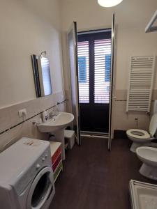 パレルモにあるCasa vacanza Pupiddaのバスルーム(トイレ2つ、シンク、洗濯機付)