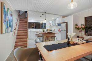 a kitchen and dining room with a table and chairs at Tranquil Sunset Retreat - Spa - WIFI - Netflix in Auckland