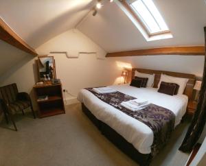 a bedroom with a large bed and a skylight at Rooms at the Apple Pie in Ambleside