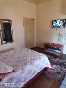 a bedroom with a bed and a tv on the wall at New Dawn Guest House in Brakpan