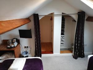 a bedroom with a bed and a tv in a room at Rooms at the Apple Pie in Ambleside