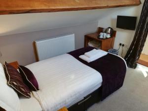 a bedroom with two beds in a room with a television at Rooms at the Apple Pie in Ambleside