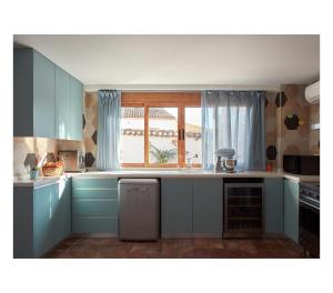 una cocina con armarios azules y una ventana en Casa Neleman, 