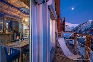 une chambre avec une table et des chaises sur un balcon avec des montagnes dans l'établissement Appartement charmant à Orcières avec vue sur montagne, à Orcières