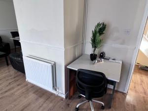 a desk with a chair and a plant on it at 3 Bedroom House with Garden in Buckinghamshire