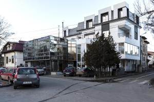 a white building with cars parked in front of it at Vila Classic in Galaţi