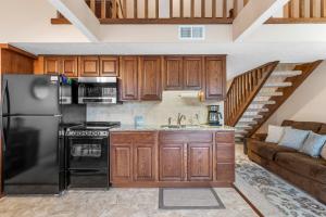 a kitchen with a black refrigerator and a staircase at 2 Bed 2 Bath Fall Creek Condo in Branson