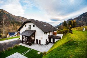 uma vista aérea de uma casa branca com montanhas ao fundo em Hiša 109 em Kranjska Gora