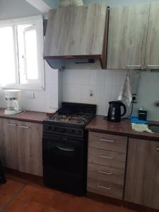 a kitchen with a black stove and a window at Departamento Brown - zona centro in Mar del Plata +3 photos