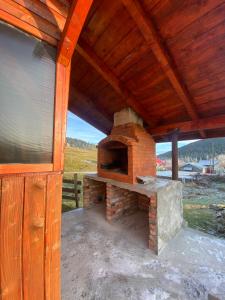 un horno de ladrillo al aire libre sentado bajo un techo de madera en Cabana Corina, en Vartop