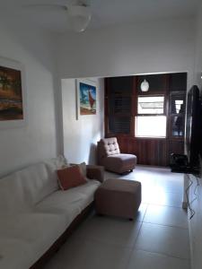 sala de estar con sofá blanco y TV en Apartamento Departamento Central Playa para max 5, en Cassino
