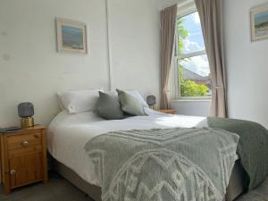 een slaapkamer met een groot bed en een raam bij The Dragonfly BNB, Glastonbury in Glastonbury