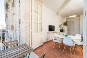 Zimmer mit einem Tisch und Stühlen sowie einem Balkon in der Unterkunft Maestranza72 by Bed&Bros in Syrakus