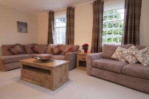 a living room with a couch and a table at Craigievern Holiday Cottage in Drymen