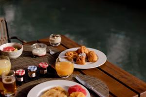 a table with two plates of breakfast foods and orange juice at Nobu Hotel Marrakech in Marrakesh