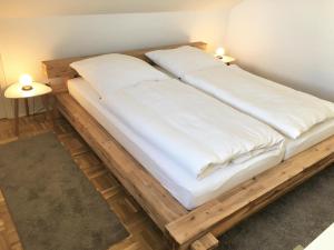 a bed frame made out of wood with two pillows at Ferienwohnung Koje in Wees