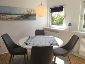 a dining room with a white table and chairs at Ferienwohnung Koje in Wees
