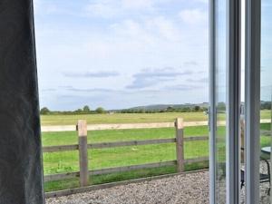 una ventana con vistas a un campo con una valla en The White Horse View B&B, en Shrivenham