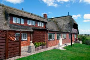 an old house with a thatched roof and a yard at Friesenhof Küper in Dagebüll