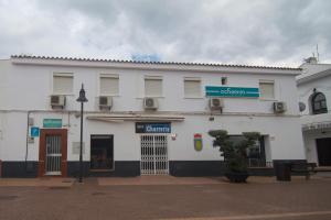 un edificio blanco con un letrero en la calle en Ochomin Hostel, en San Martín del Tesorillo