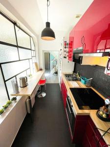 cocina con armarios rojos y suelo negro en Coeur Feydeau Kervegan le Duplex hyper centre en Nantes