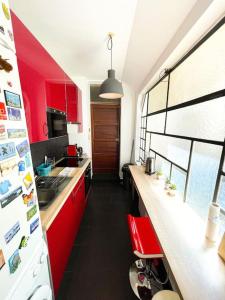 cocina con armarios rojos y nevera blanca en Coeur Feydeau Kervegan le Duplex hyper centre en Nantes