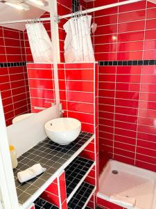 un bagno piastrellato rosso con servizi igienici e lavandino di Coeur Feydeau Kervegan le Duplex hyper centre a Nantes