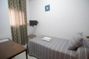 1 dormitorio con 1 cama con 2 toallas en Ochomin Hostel, en San Martín del Tesorillo