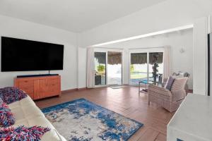 Beach Walk Residences في شاطئ بالم إيغل: غرفة معيشة مع تلفزيون بشاشة مسطحة وأريكة
