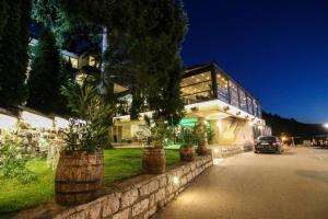 a building with potted plants in front of it at Hotel Happy in Dimitrovgrad