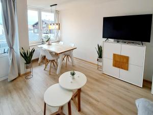 a living room with a table and a flat screen tv at Schmidis Ferienwohnung Sonthofen in Sonthofen
