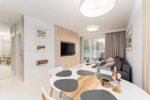 a living room with a table and chairs and a couch at Sunrise Apartament in Rogowo