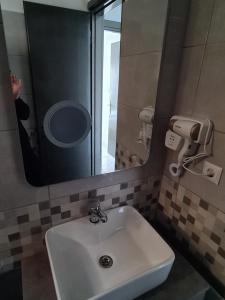 a person taking a picture of a bathroom sink at Harbour Lounge rooms in Kardamaina