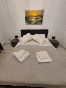 a large bed with two white towels on it at Harbour Lounge rooms in Kardamaina