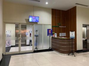 a lobby with a counter and a tv on the wall at APARTEMEN MARGONDA RESIDENCE 3 DEPOK BY DBancah Rooms in Kemirimuka Tiga